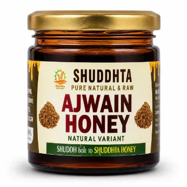 A jar of Shuddhta Ajwain Honey with a gold lid and cream-colored label, set against a plain white background.