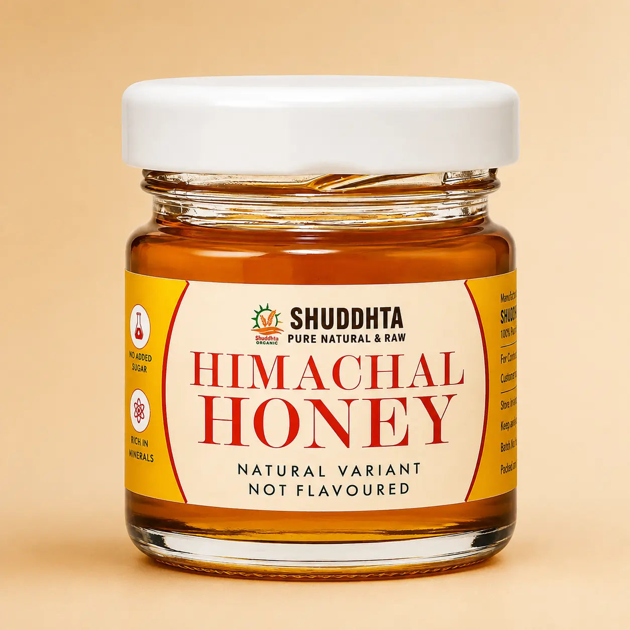 A jar of Shuddhta Wild Forest Honey with a white lid and cream label, set against a warm beige background with soft leaf shadows.