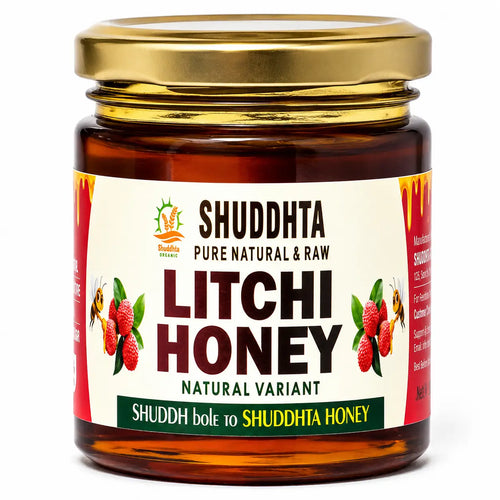 A jar of Shuddhta Litchi Honey with a gold metal lid and a cream-colored label featuring illustrations of red litchi fruits and bees, set against a plain white background.