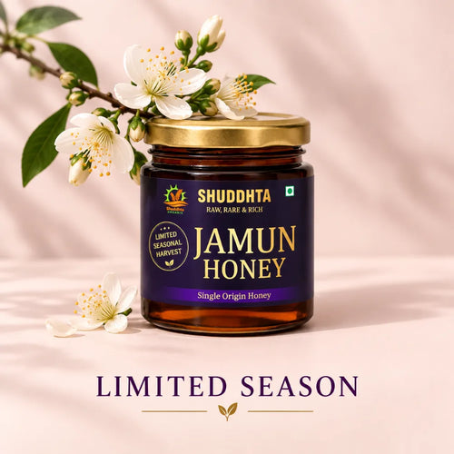 A jar of Shuddhta Jamun Honey with a gold lid and dark amber label, styled with white blossoms on a soft pink background. The text 'LIMITED SEASON' appears below the jar.