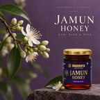 Shuddhta Jamun Honey jar on a stone surface with white flowers and leaves against a purple background