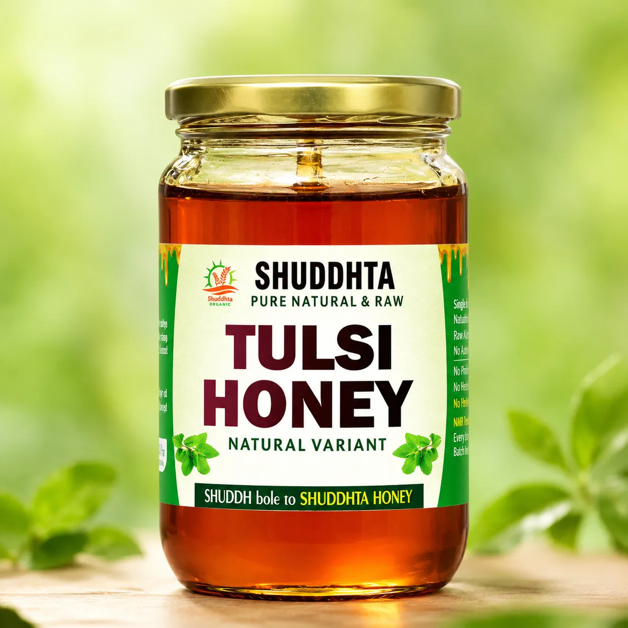 A jar of Shuddhta Tulsi Honey with a gold lid and white label, set against a soft green bokeh background with blurred leaves.