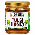 A jar of Shuddhta Tulsi Honey with a gold metal lid and a white label featuring green and red text, set against a plain white background.