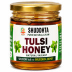 A jar of Shuddhta Tulsi Honey with a gold metal lid and a white label featuring green and red text, set against a plain white background.